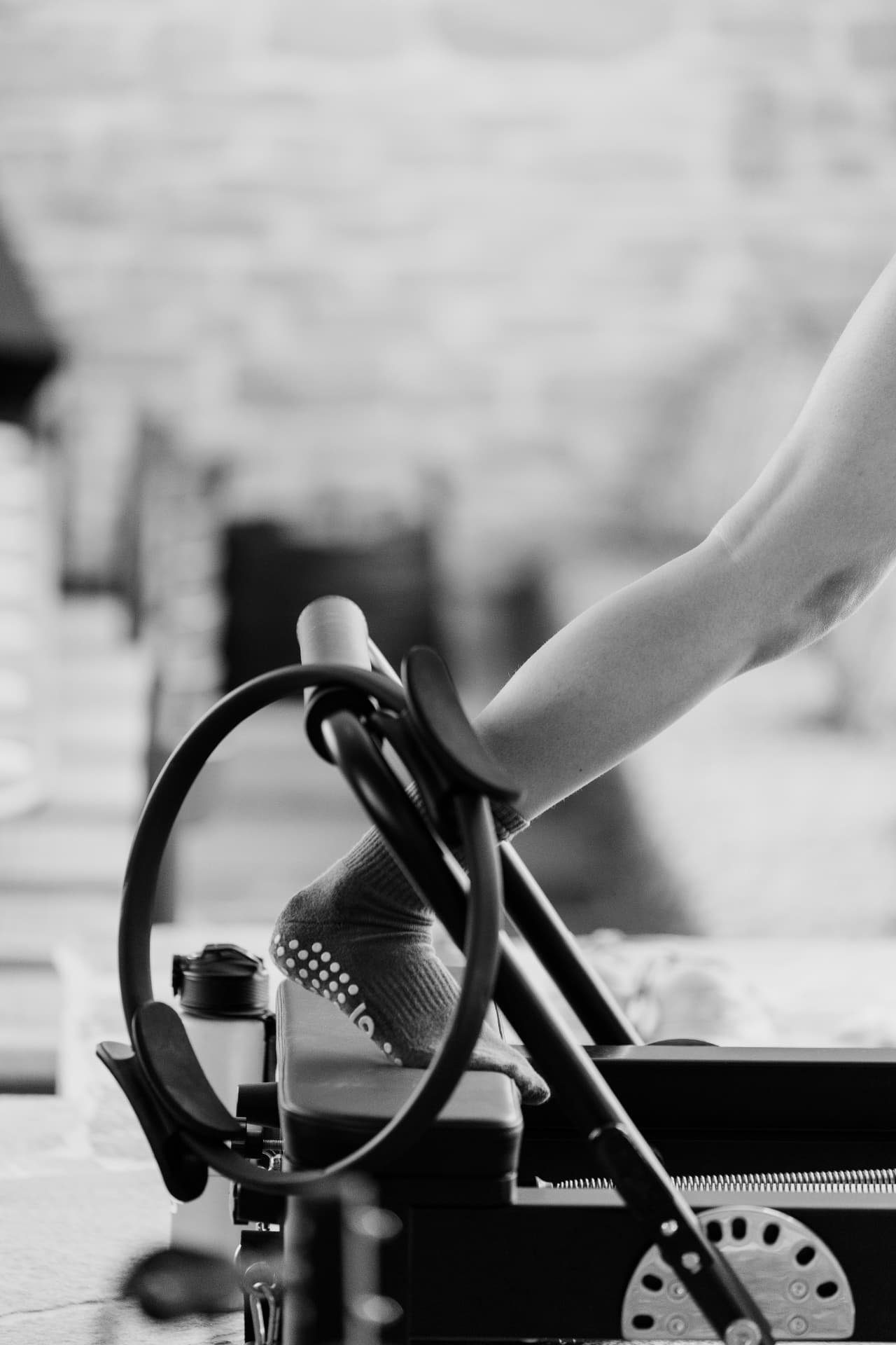 Detail van een oefening met pilatesring op de reformer